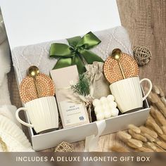 a gift box with coffee mugs, soap and other items in it on a table