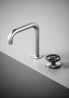 a faucet with a metal spout next to it on top of a counter