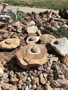 there are many rocks that have been placed on the side of the road with bikes in the background