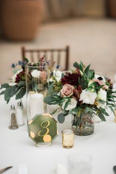 the table is set with flowers and candles for an elegant wedding reception or special event