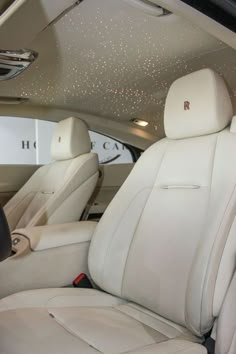 the interior of a car with white leather seats