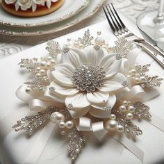 a close up of a napkin with flowers and pearls on the edge, along with other place settings