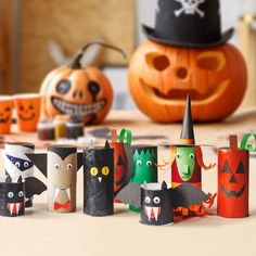 halloween decorations made out of toilet paper on a table with pumpkins in the background