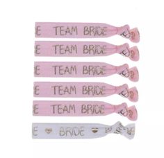 five pink and white hair clips with the words'team bride'written on them