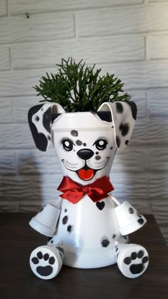 a ceramic dalmatian planter with a red bow on it