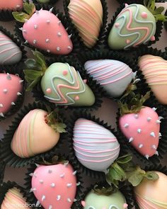 chocolate covered strawberries with pink and green frosting on them are arranged in rows