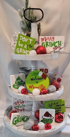 three tiered trays with christmas cards and ornaments on them, each decorated in different colors