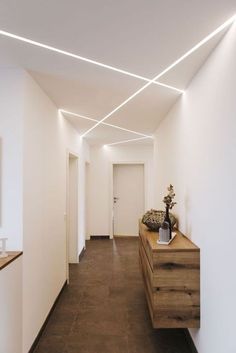 a long hallway with white walls and wooden furniture