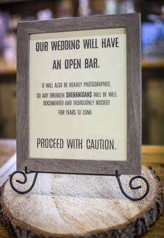 a sign that is sitting on top of a tree stump in front of a bar