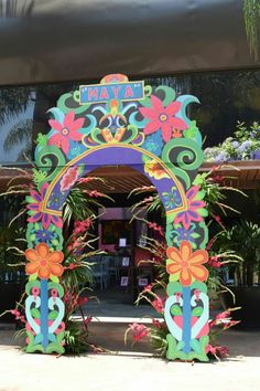 an elaborately decorated entrance to a restaurant with flowers on the sides and plants at the bottom