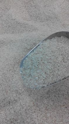 a spoon full of rice sitting on the ground