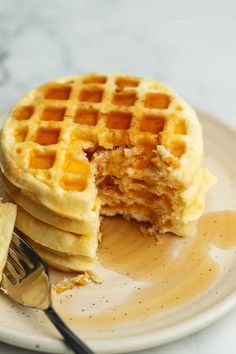 a stack of waffles on a plate with syrup