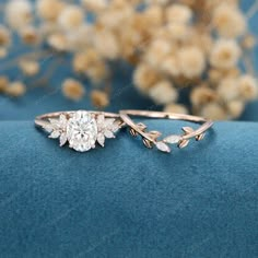 a close up view of a diamond ring on a blue surface with flowers in the background