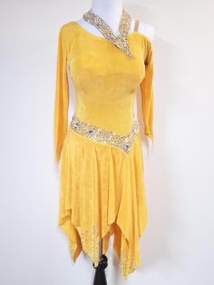 a yellow dress with sequins on the neckline and skirt is displayed in front of a white wall