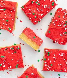 red cake with white and green sprinkles cut into squares on a plate