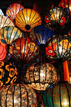 many colorful lanterns are hanging from the ceiling