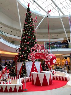 a large christmas tree in the middle of a shopping mall with decorations on it's sides