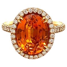 This phenomenal ladies' ring boasts an impressive total carat weight of 9.28 carats and showcases a breathtaking orange sapphire encircled by a halo of dazzling diamonds. It has been meticulously certified by GIA to provide complete quality assurance. With its exceptional design and mesmerizing gemstones, this ring is an unequivocally unique piece of jewelry that is guaranteed to make an unforgettable statement. SPECIFICATIONS: -Metal Type: 18K Yellow Gold. Beautiful Ballerina Set -7.07 Carat Oval Cut Natural Sapphire, GIA Certified -Sapphire Color: Orange -Sapphire Measurements: 12.43 x 9.60 x 6.68 mm -2.21 Carat Round Natural side Diamonds. E-F Color, VS Clarity -Size 6.5 Made in New York City. Orange Jewelry, Ladies Ring, Sapphire Color, Orange Sapphire, Natural Sapphire, Diamond Halo, Sapphire Diamond, Yellow And Brown, Quality Assurance