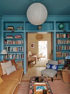 a living room filled with furniture and bookshelves covered in lots of bookcases