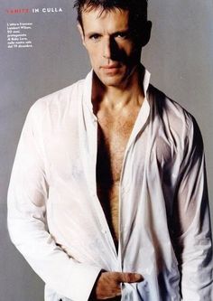 a man in white shirt and jeans posing for a magazine cover with his hands on his hips