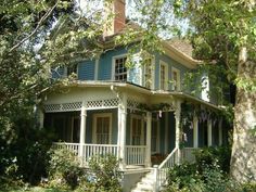 a blue and white house surrounded by trees