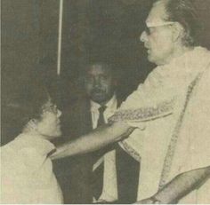 an old black and white photo of a man shaking hands with a woman in front of him