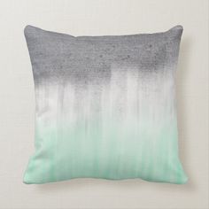 a gray and green ombreed pillow sitting on top of a white wall