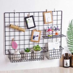 there is a wire rack with pictures and plants on it