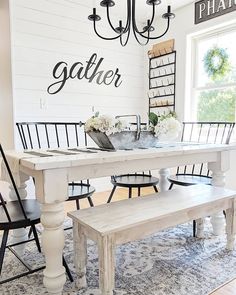 a dining room table with chairs and a bench in front of the chandelier