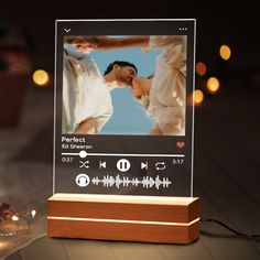 a wooden block with an image of two people on it and lights in the background