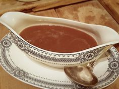 a gravy dish with a spoon on a plate