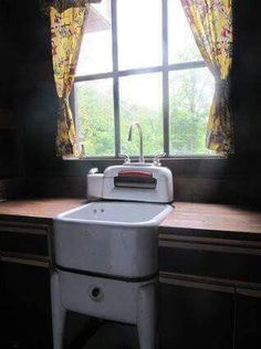 a kitchen sink sitting under a window next to a counter