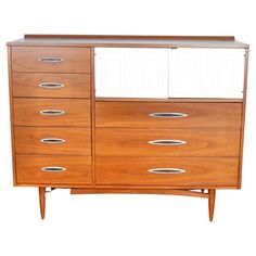 a large wooden dresser with many drawers and doors on it's front side, against a white background