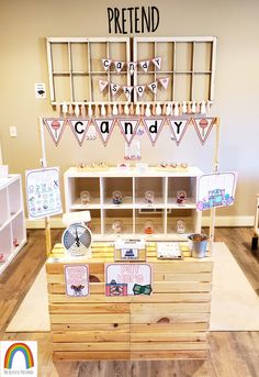 the pretend candy shop has wooden crates and signs on it's display shelves for sale