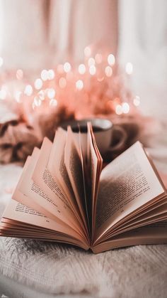 an open book sitting on top of a bed