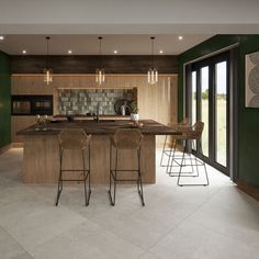 a kitchen with an island and bar stools in the center, surrounded by green walls