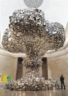 a woman standing in front of a large metal sculpture