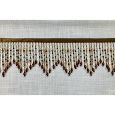 a beaded curtain hanging on the side of a white wall with red beads and brown trim