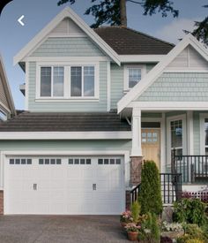 a large house with two garages on the front and one above it's door