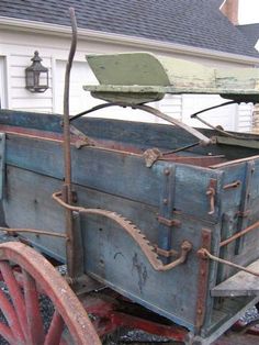 an old blue wagon sitting in front of a white house