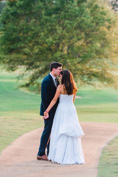 a bride and groom standing on a path