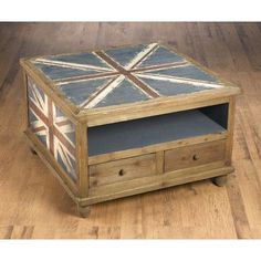 a wooden box with an union jack painted on the top and drawers below it, sitting on a wood floor