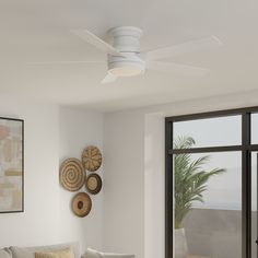 a living room filled with furniture and a white ceiling fan mounted to the side of a wall