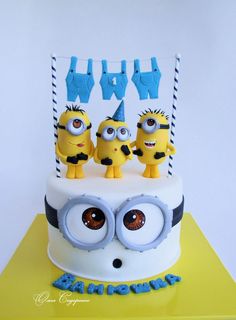 a birthday cake with three minion characters on top