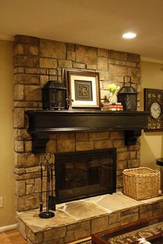 a fireplace with pictures on the mantle and other items in front of it that are displayed