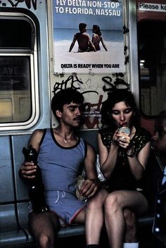 two people sitting on a bus eating and drinking