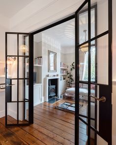 an open door leading to a living room with wood floors and furniture in the background