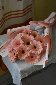 a bouquet of pink flowers sitting on top of a table