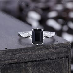 a black and white diamond ring sitting on top of a wooden table