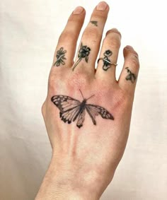 a person's hand with a butterfly tattoo on it